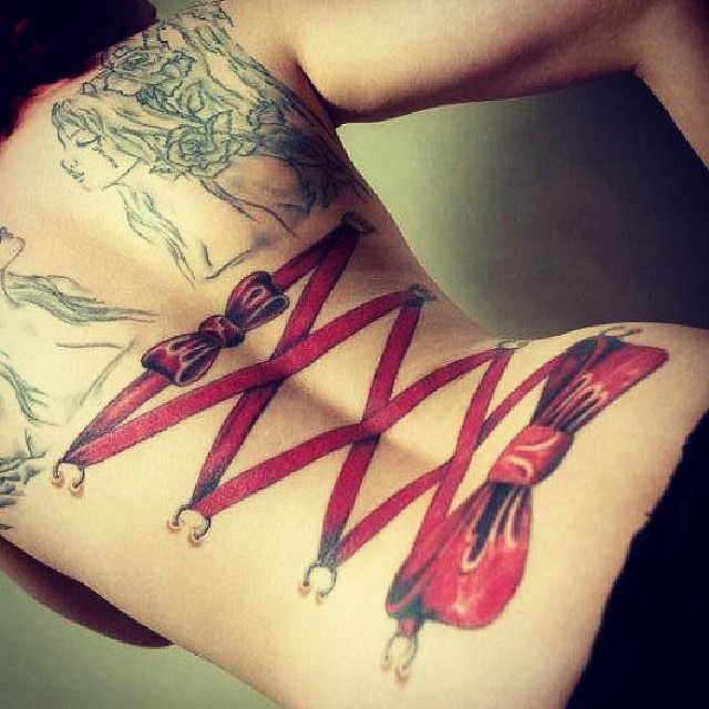 Красноволосая пышка в красном боди показала татуировку на спине