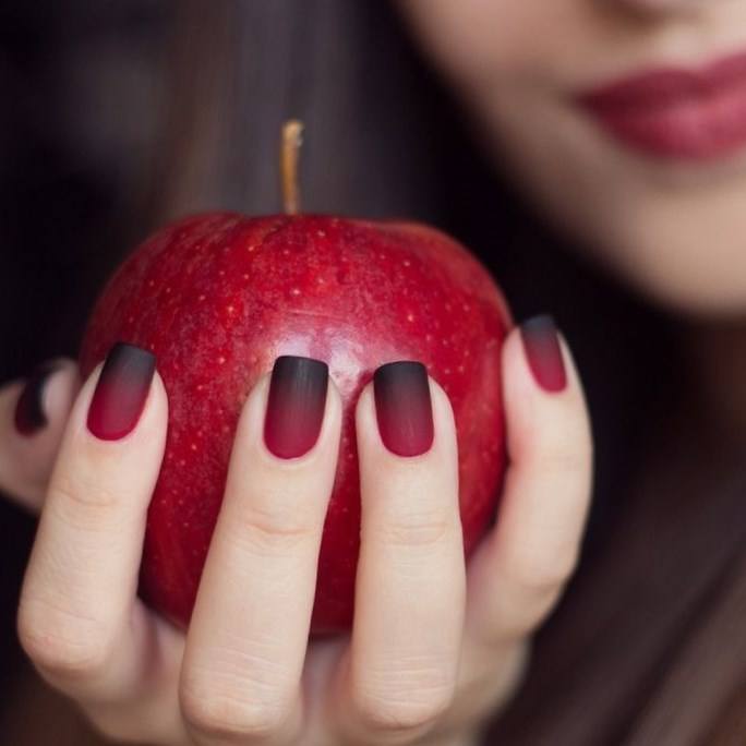 Красные ногти и яблоко
