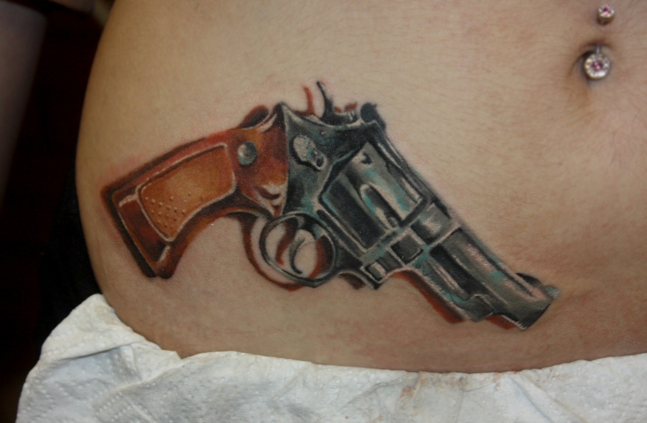Татуировки на пояснице с пистолетами